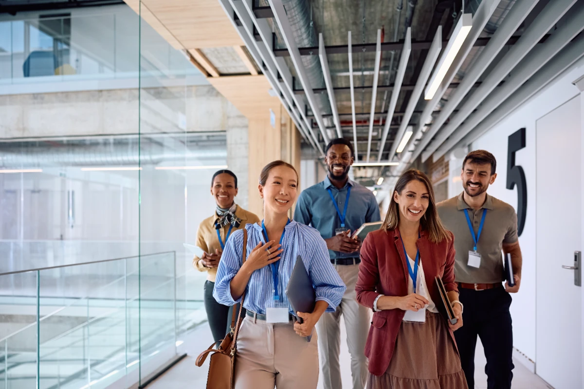 Happy diverse coworkers walking through hallway of an corporate office building.
