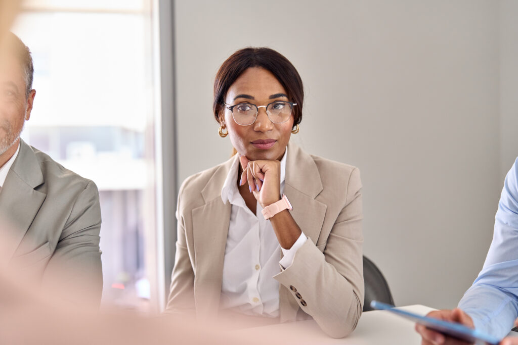 A business professional listening intently during a meeting in a boardroom.